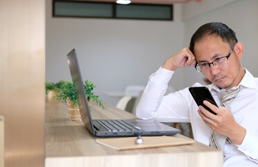 Young businessman is stressed out at work, and he is on his phone.