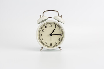 White retro clock alarm clock on white background shows 01:15 am or 01:15 pm or 13:15