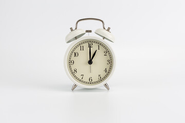 White retro clock alarm clock on white background shows 01:00 am or 01:00 pm or 13:00