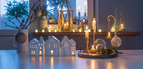 christmas toy houses with burning candles on  table