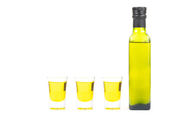 Close up oil bottle and oil in glass on white background. Health food concept.