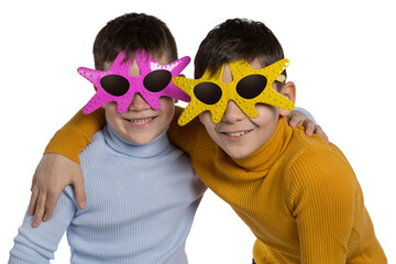 two happy boys, friends or brothers, in funny glasses in the shape of a starfish, boys smiling, cheerful holiday