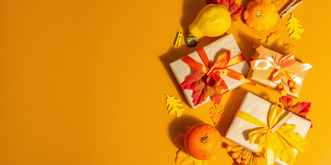Gift concept in autumn colors. Wrapped boxes, festive fall decor, pumpkin, leaves, and berries