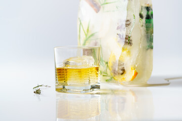 A glass of whiskey on the background of an ice cube with frozen fruit