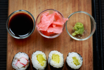 Sushi rolls with vegetable filling over dark bamboo background
