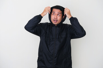 Adult Asian man covering his head with jacket during raining season