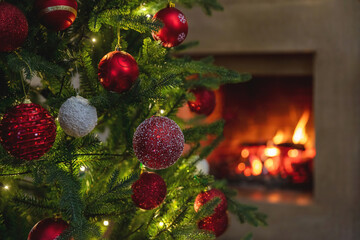 Christmas holiday home background. Warm cozy burning fireplace and Xmas tree decoration