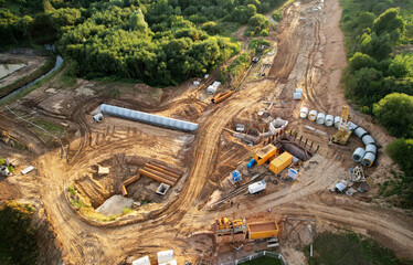 Concrete sewer pipes for laying external sewage system at construction site. Tunnel boring machine...