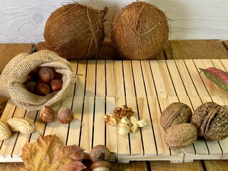 On the oak table are coconut, walnuts and hazelnuts - obrazy, fototapety, plakaty