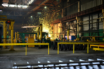 Industrial furnace in workshop forging plant for hardening steel at high temperature. Metallurgical industry, hot rolling mill. Heat treating. Sparks background in blacksmith steelmaking factory