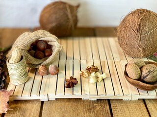 On the oak table are coconut, walnuts and hazelnuts