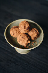 Pieces of chocolate with sweets truffle on a dark background.