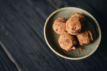 Pieces of chocolate with sweets truffle on a dark background.
