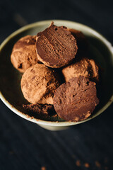 Pieces of chocolate with sweets truffle on a dark background.