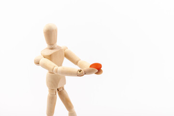 Wooden mannequin with pills on white background. Concept of pharmaceuticals and supplements.