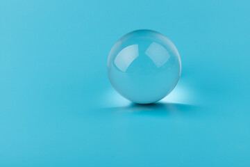 Crystal glass ball sphere transparent on blue background.