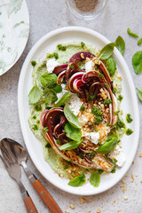 roasted radicchio salad with feta, green tahini, Pine nuts and basil pesto. Radicchio rosso di treviso tardivo, italian red chicory. Healthy Meal recipe preparation. Plant-based dishes.