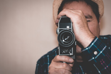 Man with Camera.cameraman make film on a retro camera.man with a plaid shirt filming with a Super 8...