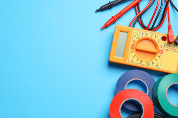 Flat lay composition with electrician's accessories on light blue background, space for text