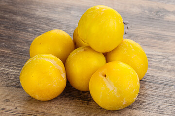 Ripe sweet yellow plum heap over background