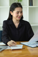 Happy businesswoman in black shirt working at her workplace.