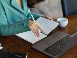 Businesswoman works on her laptop computer at her office desk.
