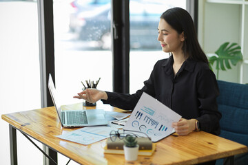 Business woman working with laptop computer and financial papers