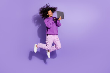 Full body portrait of carefree cheerful afro hair lady use netbook digital connection isolated on violet color background