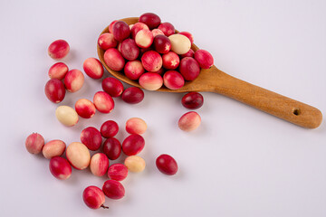 Carissa carandas and wooden spoon isolated on white background.