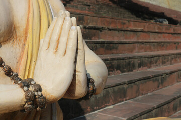 The hands of the Hindu sculpture are folded in pranam. Bow, salute to namaste.