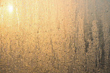 Frost pattern and sunlight on window. Frozen winter glass. Ice texture.