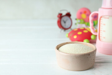 Concept of baby food with рowdered milk on white wooden table