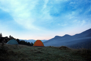 Camping tents on mountain slope in morning