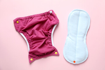 Reusable diapers on pink background, close up