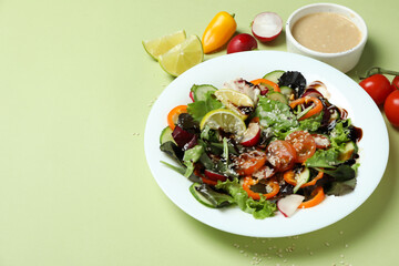 Concept of tasty food with vegetable salad with tahini sauce on green background