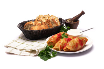 Portion of cabbage rolls stuffed with ground beef and rice with sour cream on a plate