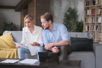 Business partners discussing deal documents reading mortgage agreement working at home office. Man...