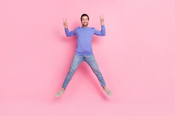 Full length photo of brunet cool young guy jump show v-sign wear blue sweater jeans footwear...