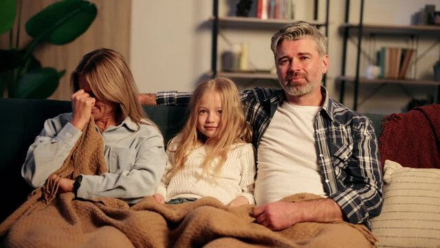Sensitive family with little daughter watch drama movie on tv. Adult couple cry while watch drama cinema or soap opera on tv. High quality 4k footage