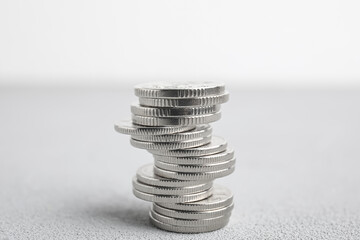 Many silver coins stacked on white table
