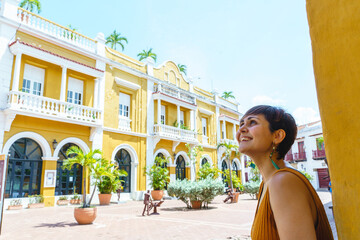 Side view of woman traveling in Cartagena de Indias. Horizontal view of latin woman sightseeing in spanish historic ancient city. Travel to Colombia concept.