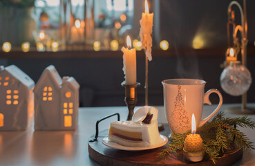 cup of tea  with cake and christmas decorations  on white table in kitchen