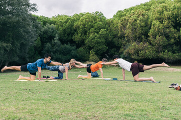Fototapeta na wymiar Group of people doing yoga outside