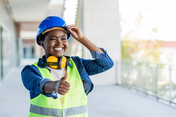 Cheerful young female engineer on a harbor showing thumb up. Cheerful female engineer smiling with...