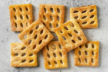 Puff pastry is spread out on a light cooking table. Delicious homemade sweet pastries top view