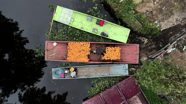 Drone shot of peasant arrange the flowers in the boat in Xochimilco, Mexico