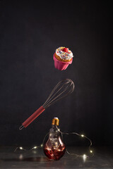 Flying in the air Easter or Christmas cupcake decorated with berries, Christmas lamps illumination...