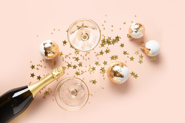 New Year champagne or sparkling wine and Christmas gold baubles on pink background for Festivity....