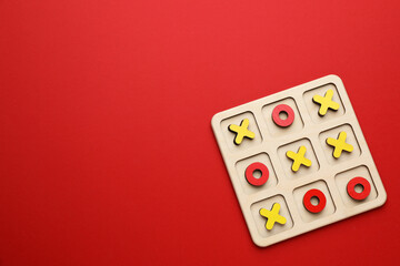 Tic tac toe set on red background, top view. Space for text