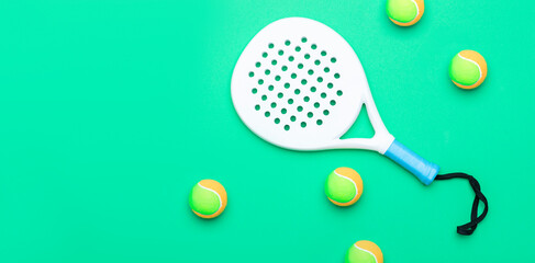 White professional paddle tennis racket and balls on mint color background. Horizontal sport theme poster, greeting cards, headers, website and app